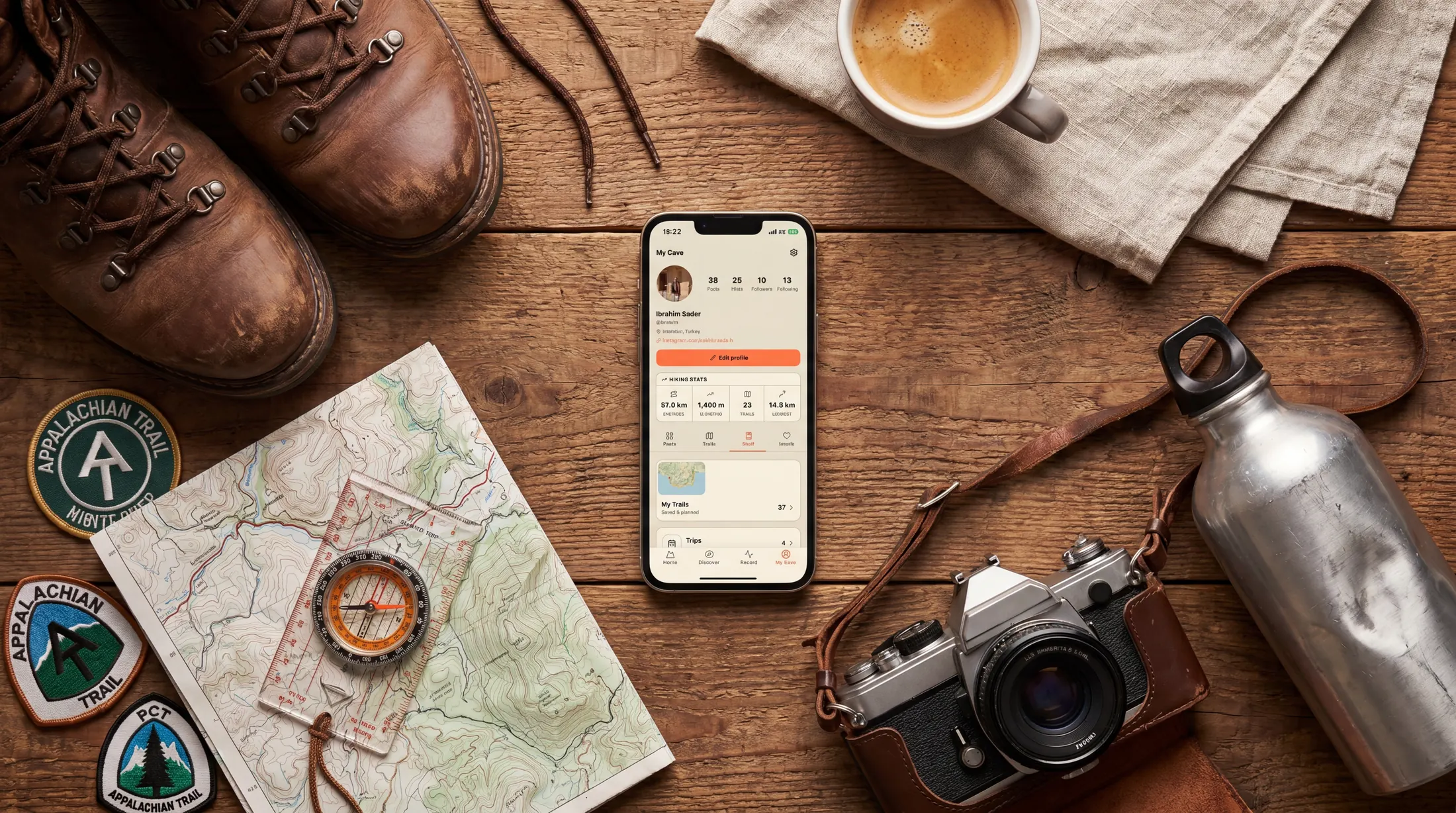 A Hikely profile and saved hiking shelf shown on a phone beside hiking gear.