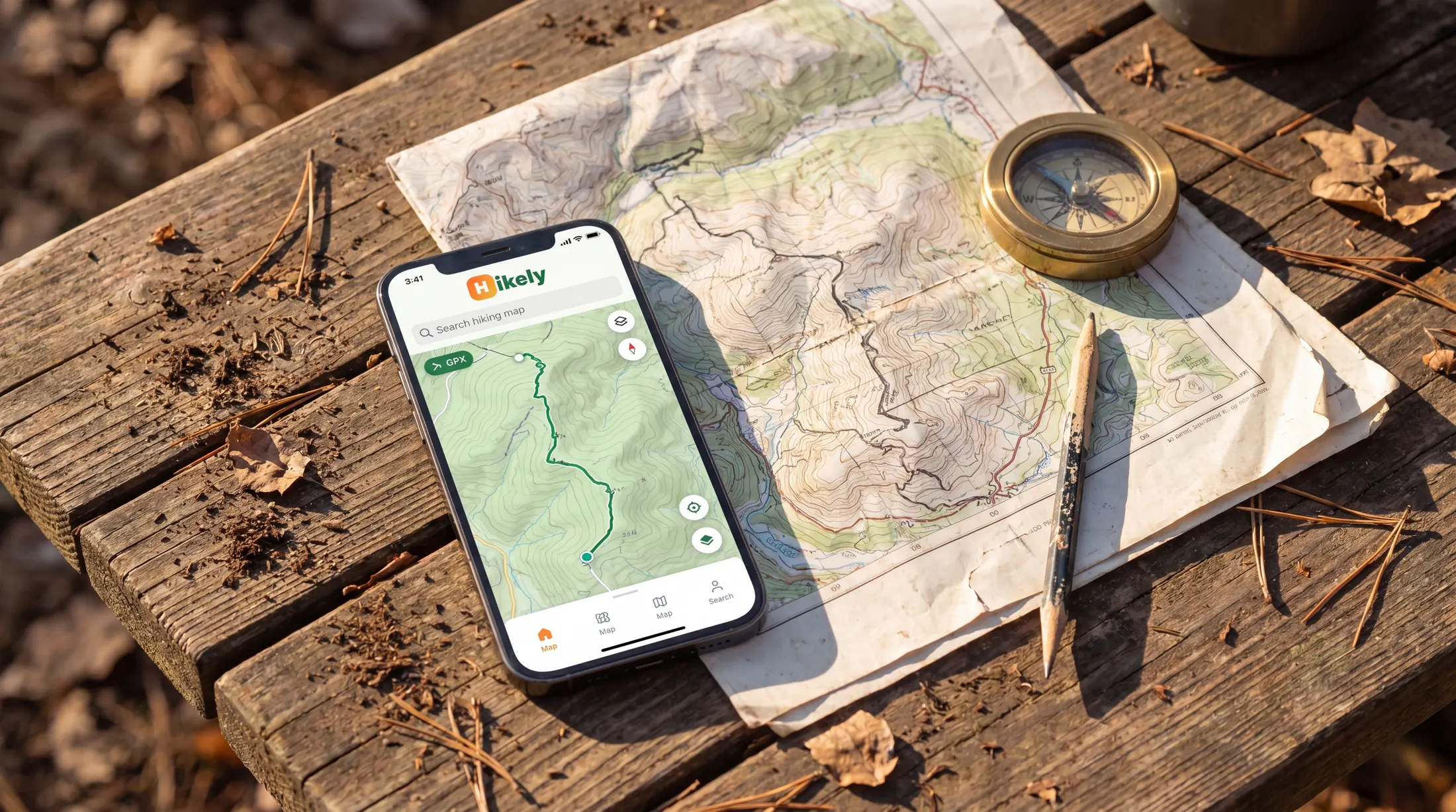 A phone with an offline hiking map and paper route planning on a table.